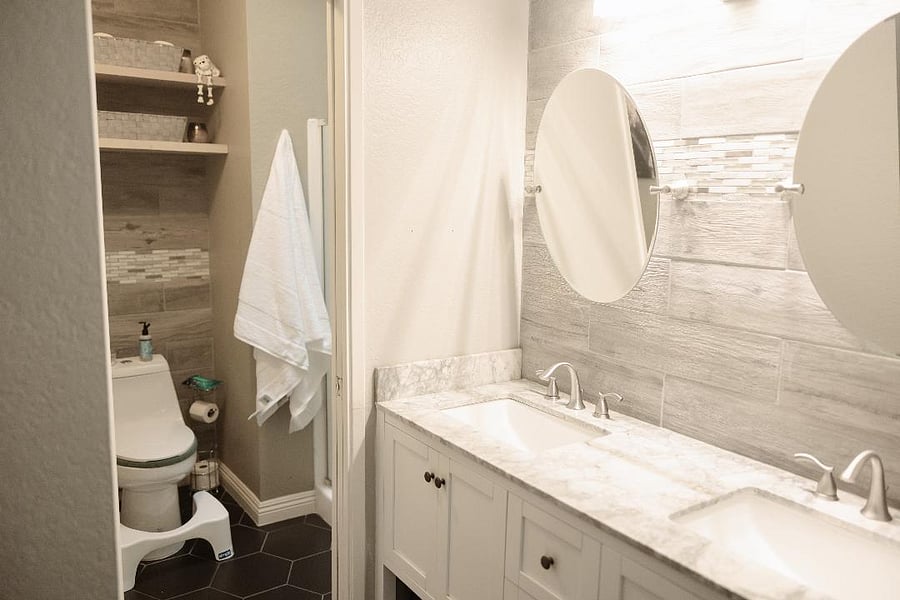 Primary/Master Bathroom features a double-sink vanity adjacent to a separate toilet. A privacy door can be drawn to separate the bedroom from the toilet. Lots of storage space in the vanity cabinets and the shelving below.
Features towel and wash-rag hanging hooks and some starter toiletries, soaps, and beauty care supplies.