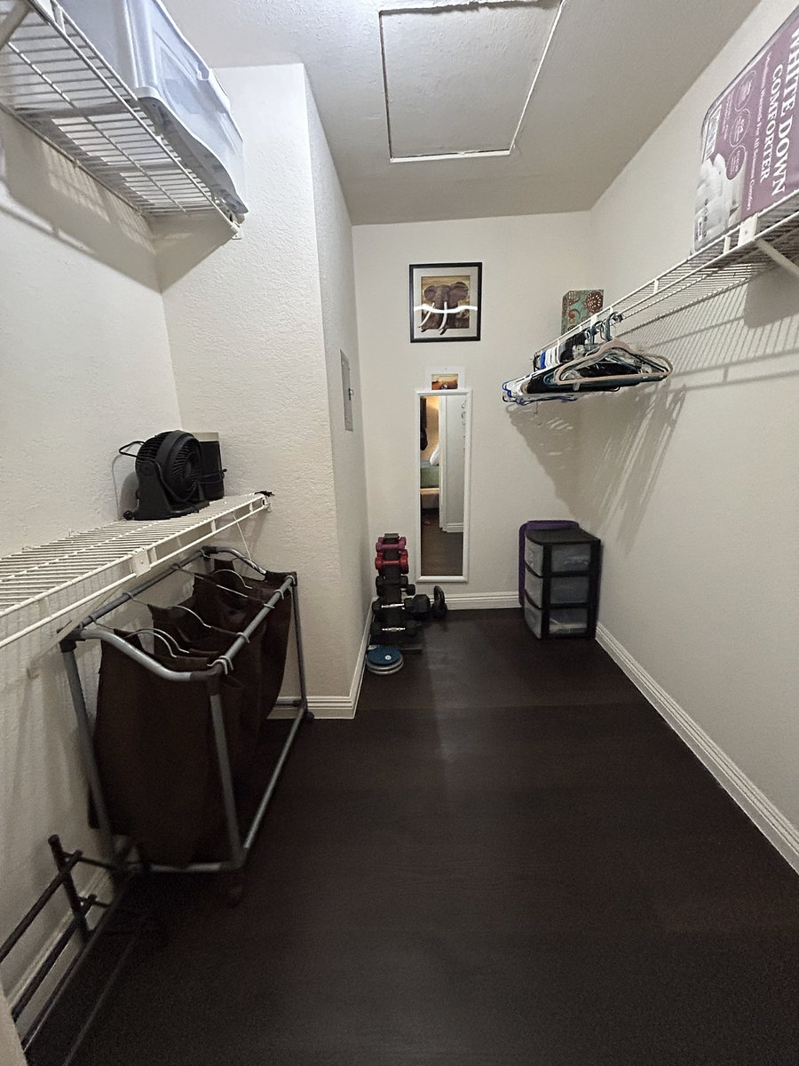 Primary/Master Bedroom Walk-in Closet. TONS of space. Comes with a mirror, five laundry hampers, three hanging racks, a floor shoe rack and a hanging shoe rack, kettlebells/free weights, extra hangers, and ample space for clothing and general storage. Portable fan and heater included for cooling or warming while working at the desk or anywhere else!