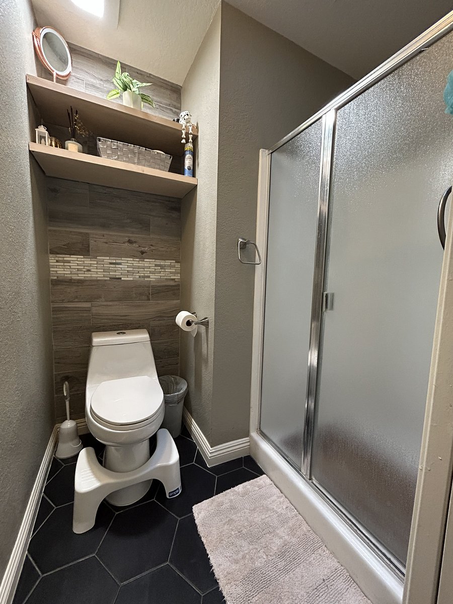 Primary/Master Bedroom toilet features storage shelves, a skylight, and a rain shower head.
Primary/Master bedroom features towel and wash-rag hanging hooks and some starter toiletries, soaps, and beauty care supplies.