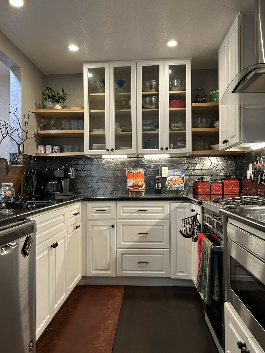 Kitchen. Gorgeous metallic backdrop and black marble countertops with plenty of space for cooking -- or opening up your takeout. Features everything a kitchen needs: spices, utensils, cookware, dishes, starter dried goods, fridge, tucked-in microwave, coffee machine, and storage.