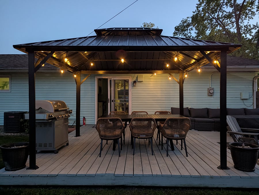 The porch transforms into a cozy retreat under the string lights!