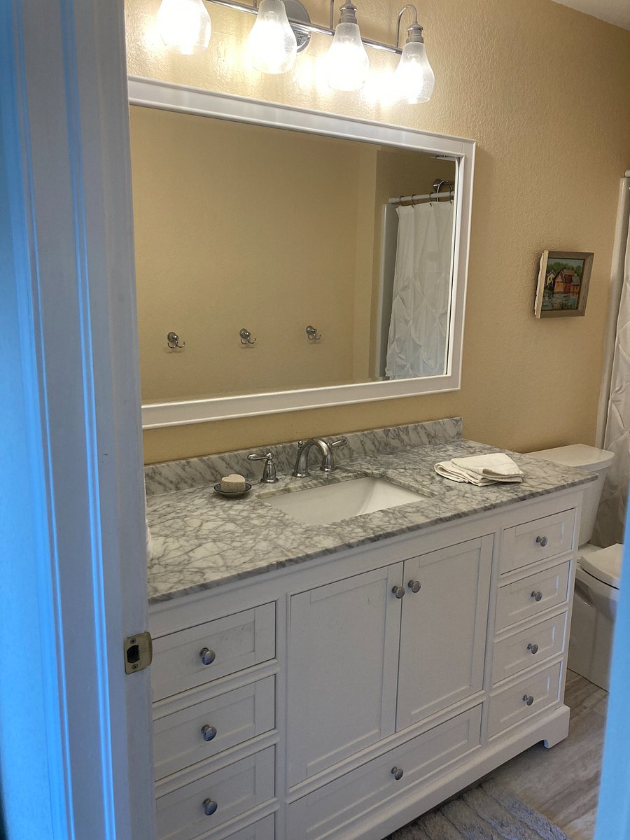 Guest room has an en-suite bathroom with updated vanity and rain shower.
