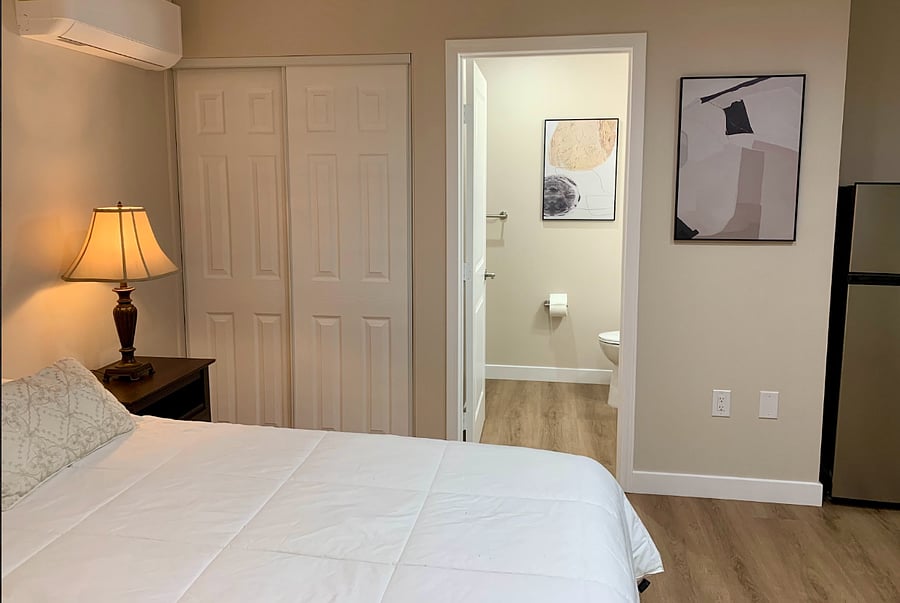 Comfortable queen-size bed with side tables for storage and a spacious closetoffering both relaxation and practicality for your stay.