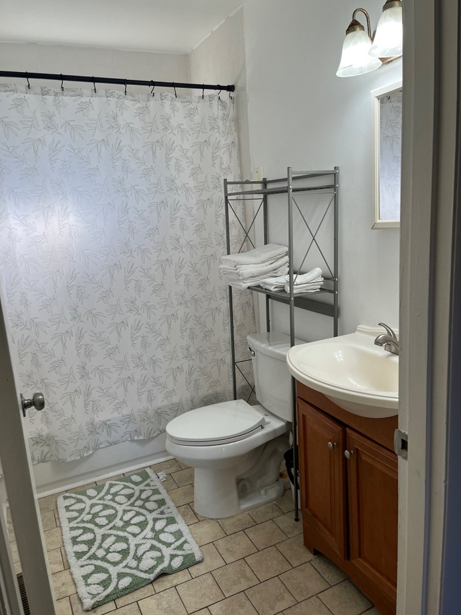 Shared bathroom with east facing exterior window.  Ample lighting, outfitted with linens, and starter shampoo, conditioner, body wash, and cleaning supplies