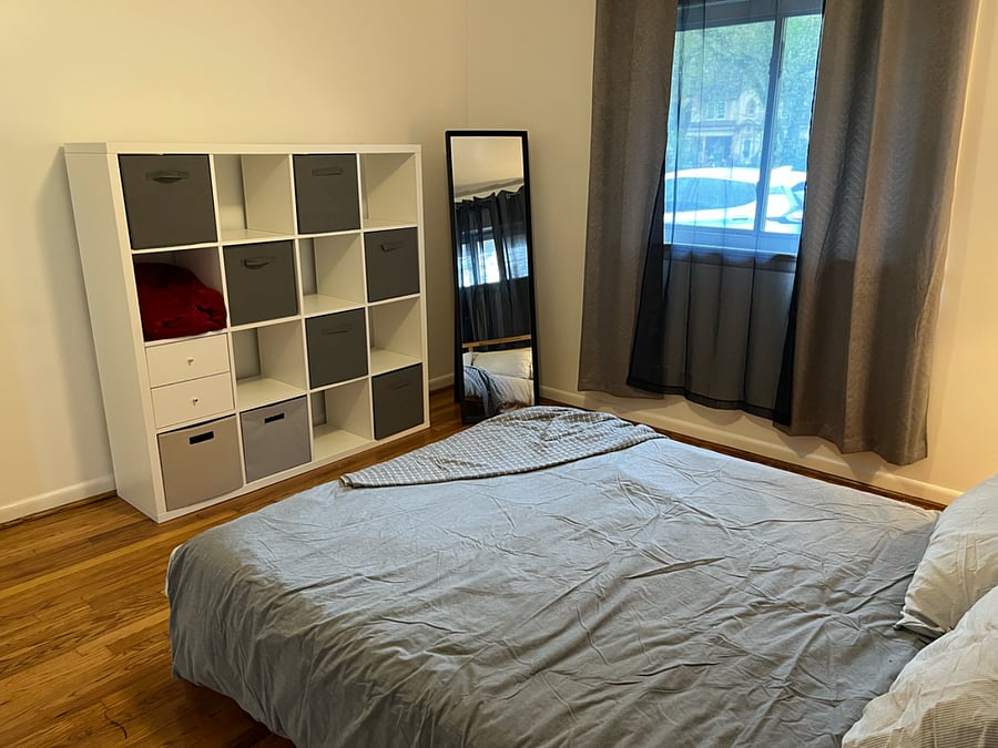 Bedroom #1. Outfitted with queen sized bed, pillows, sheets, cube shelving (utilized as a dresser), nightstand, and closet.  Located on the east 