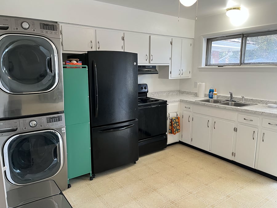 Kitchen operation across from breakfast pantry.  Outfitted with cooktop and oven, full refrigerator, and a full washer and dryer. 