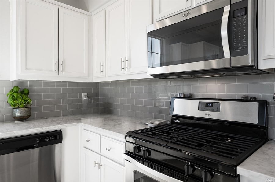 Modern kitchen with stainless steel appliances and gas range.