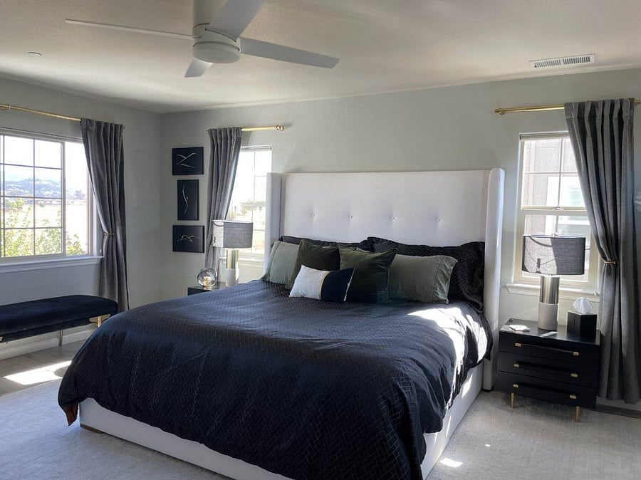 Primary bedroom featuring a king-size bed, large windows, and a calm, hotel-style feel.
