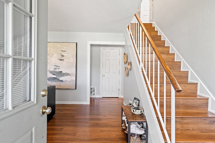 SHARED main entrance. Looking in through the front door, with the garage door directly in front of the stairs leading up to the upstairs suite. This gives the tenant direct access to their living area without needing to walk through the main living area downstairs if they don't want to. 