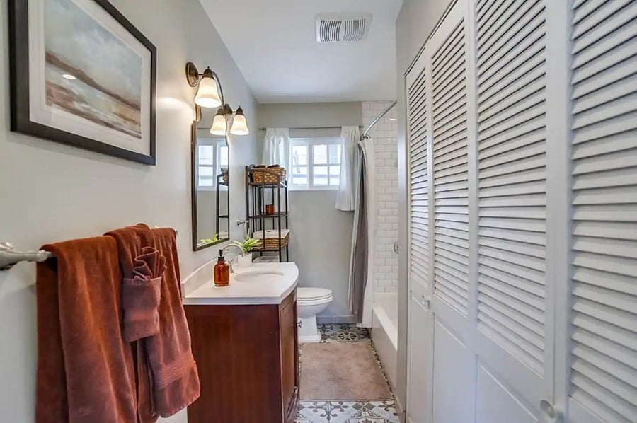 Sunny bathroom with in-unit washer and dryer located in closet on the right.