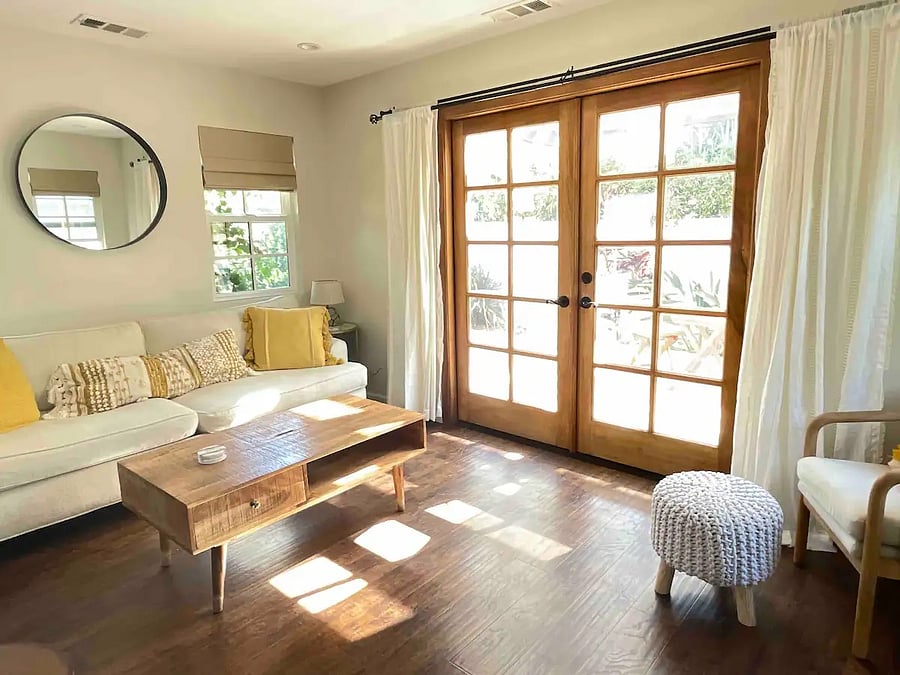 Bright and sunny living room with large French doors opening up to the private patio.