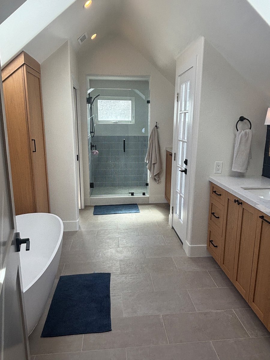 Primary bathroom with walk-out patio, large shower, soaking tub, heated floors, closet space, and double vanity