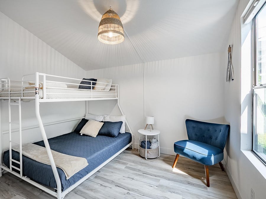Cozy bunk bedroom with stylish seating and natural light