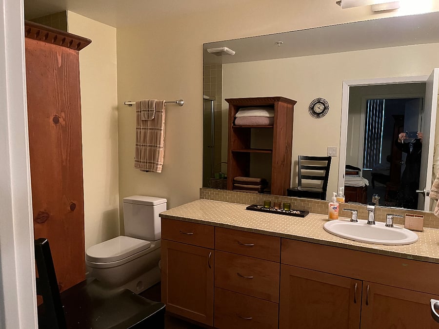 Glass tiled bathroom, complete with towels, and storage.