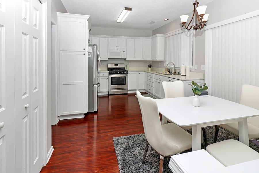 Enjoy meals together in this bright, cozy dining area, where warm wood floors and a welcoming atmosphere make every gathering feel special.