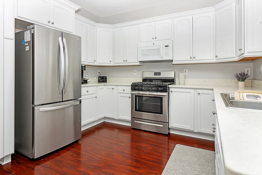 Cook and gather in this bright kitchen, featuring stainless steel appliances, plenty of storage, and warm wood floors that make it feel inviting and homey.