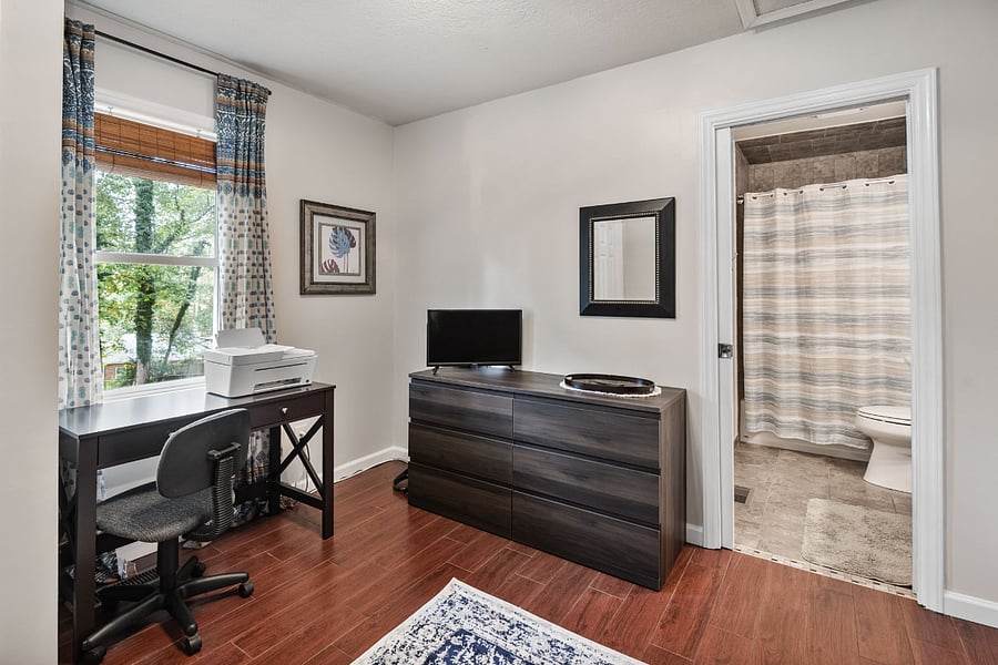 Guest bedroom/office. Room features a full size murphy bed, closet, desk, dresser, and full bathroom