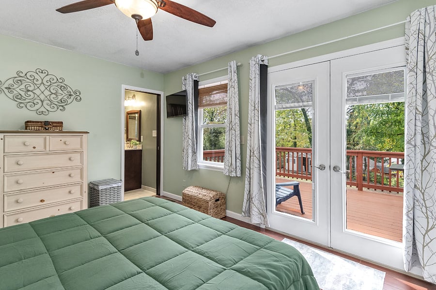 Primary suite features queen size bed, ample closet space full bathroom, and deck access.