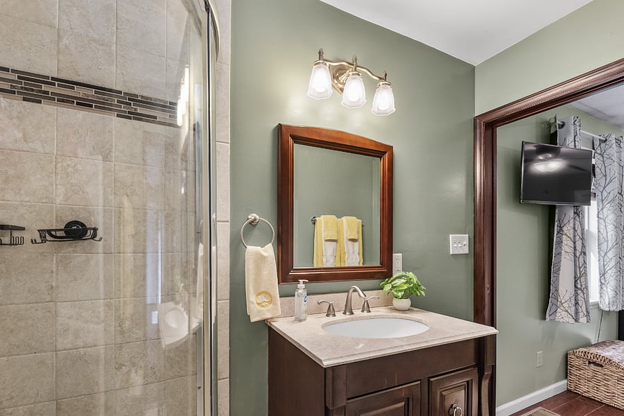 Primary bathroom features standing shower, exhaust, washer & dryer.