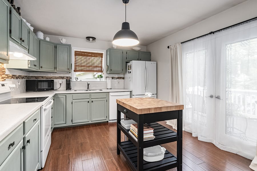 Kitchen features microwave, Keurig coffeemaker, full size stove and oven, full size refrigerator, small island, and access to front deck.