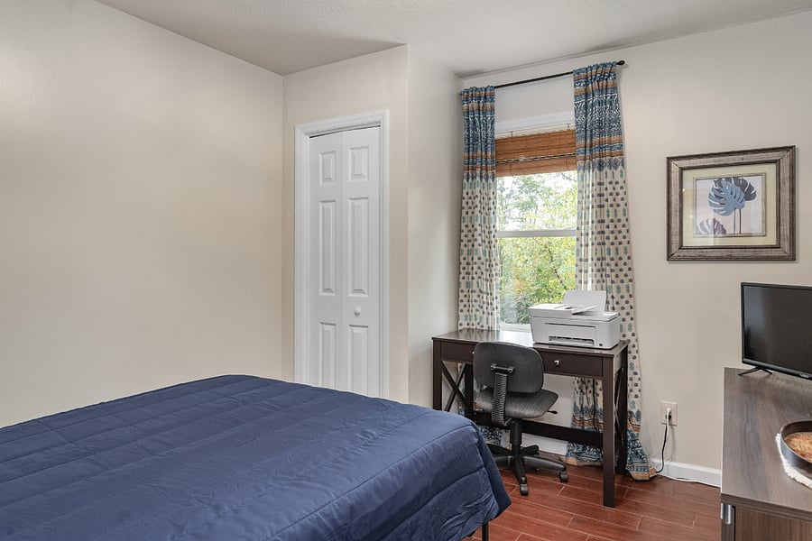 Guest bedroom/office. Room features a full size murphy bed, closet, desk, dresser, and full bathroom.