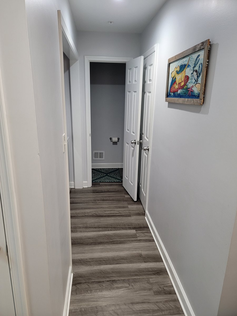 Hallway by washer dryer leading to half bathroom downstairs