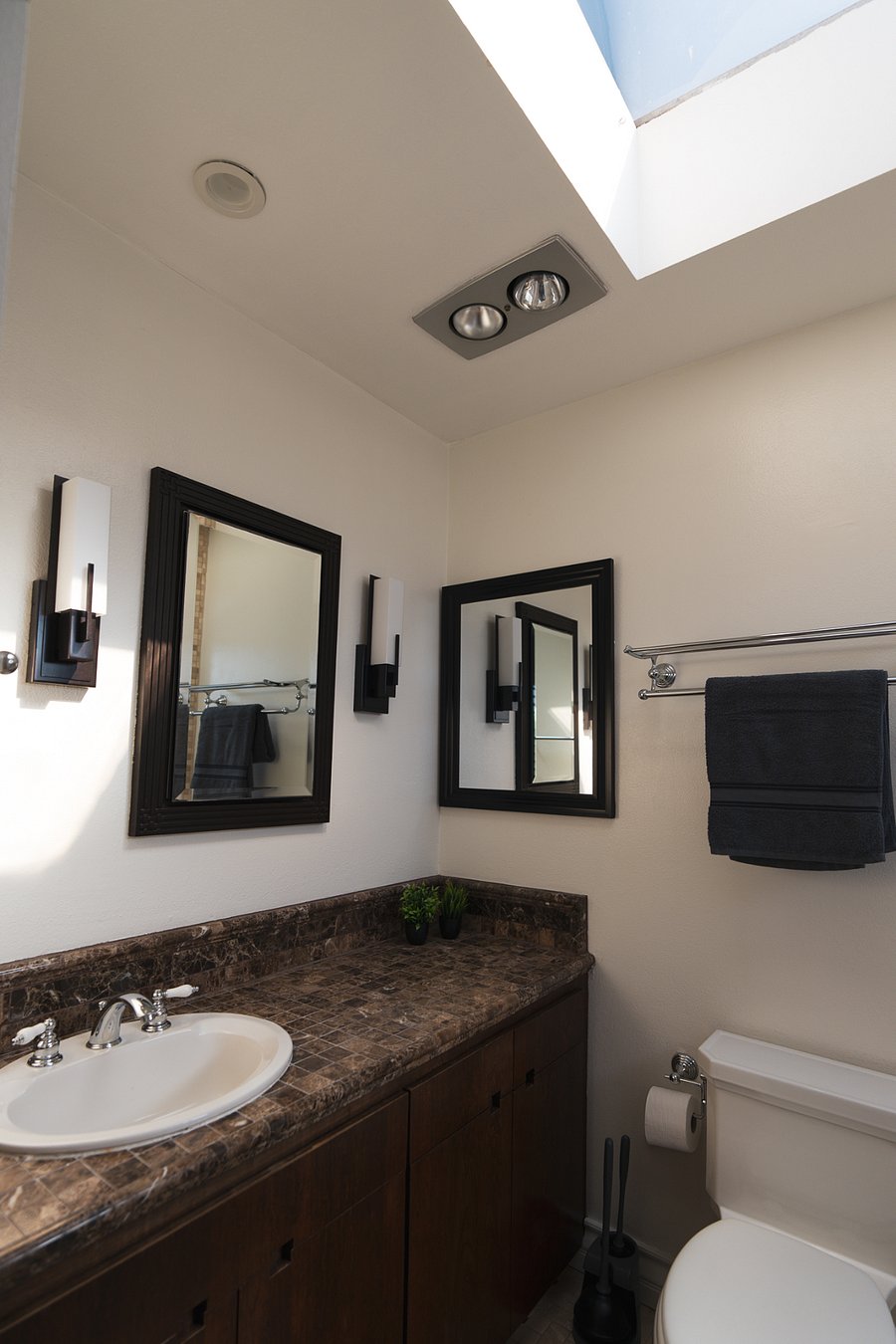 Guest bedroom bathroom.  The bathroom is bathed in sunlight from the skylight above