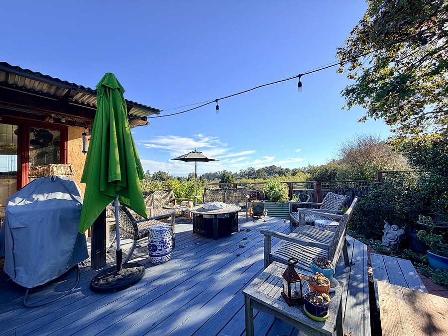 Deck sitting area with Solo fire pit, gas BBQ, and park and bay views
