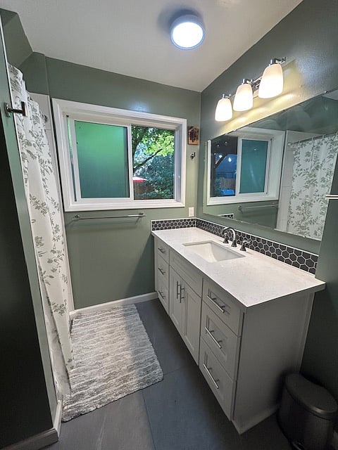 Newly remodeled bathroom with quartz countertops and luxury vinyl tile floors.