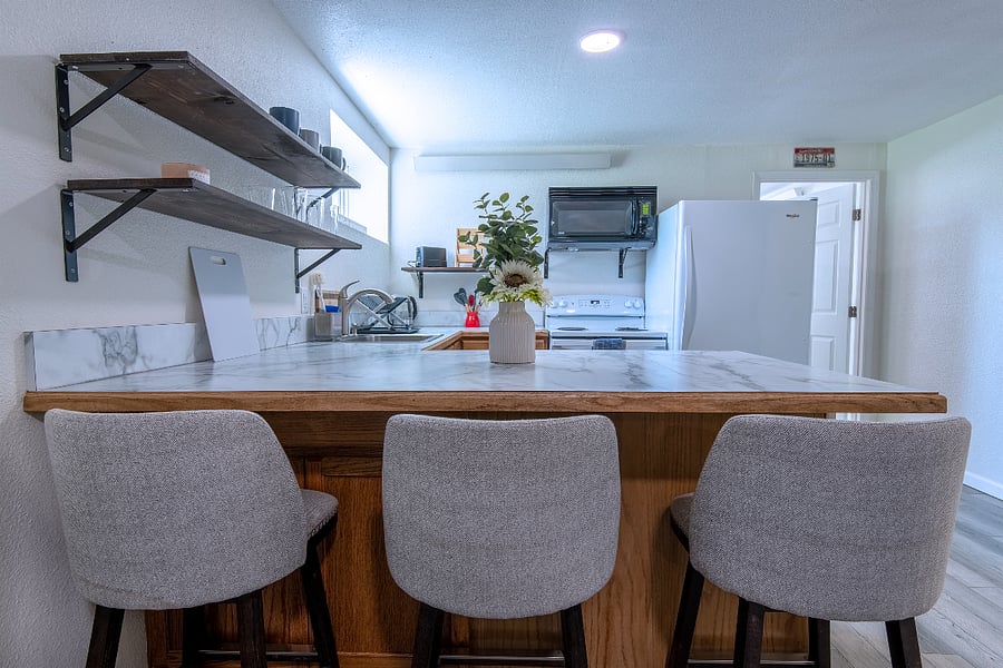 Cozy counter with bar stools in full kitchen.