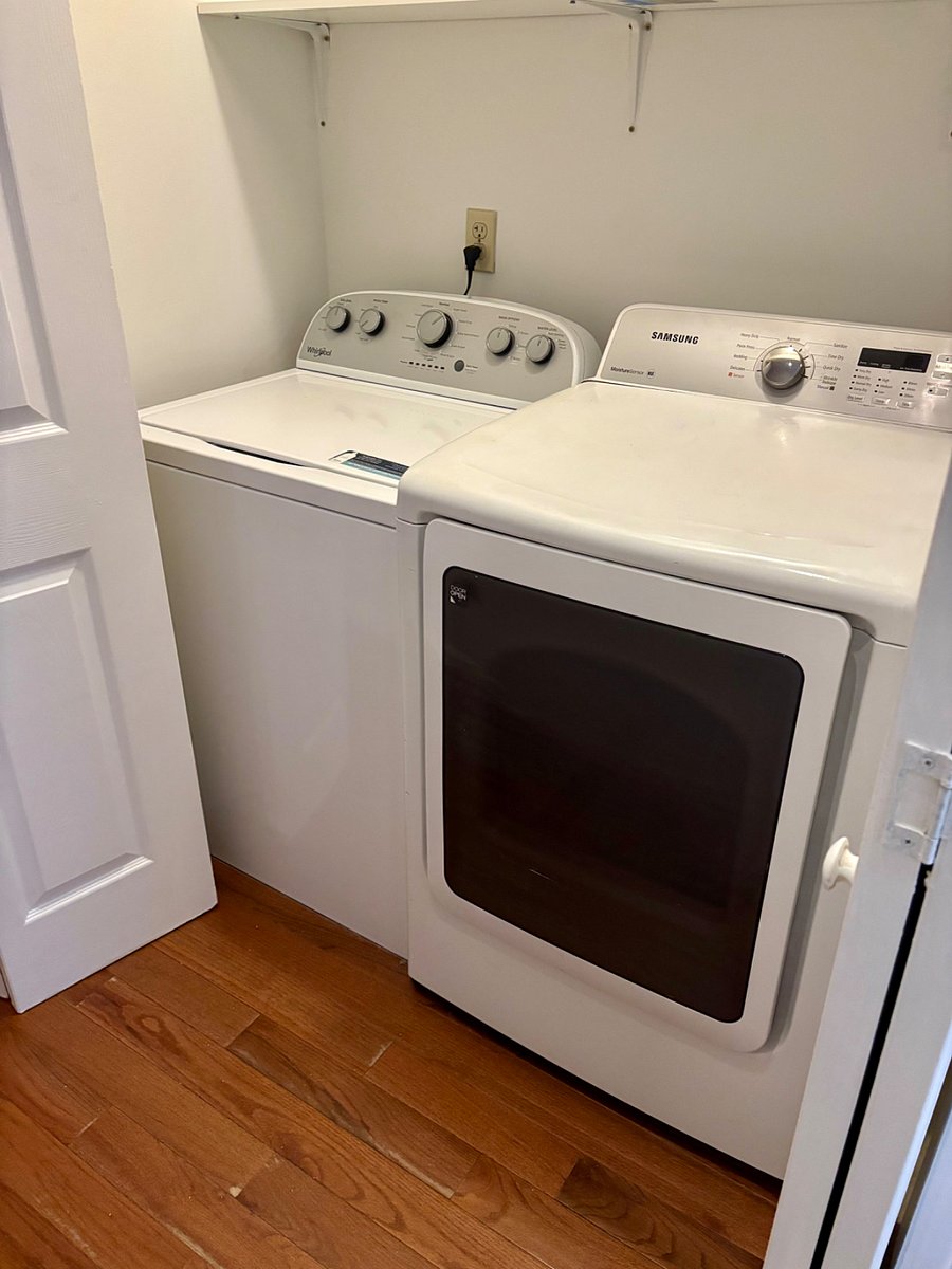 Laundry room with washer/dryer located behind accordion doors in hallway leading to bedrooms