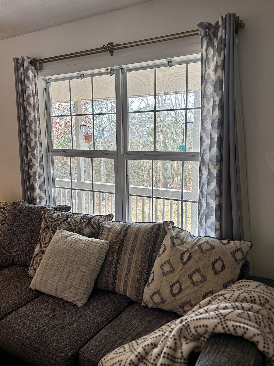 Living room with comfortable L-shaped coach and 60 inch mounted smart TV. Door leads to side porch with seating area overlooking yard.