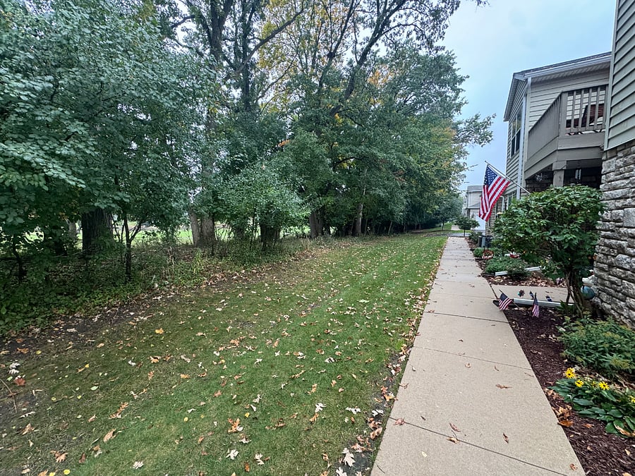 Sidewalk that goes from the 2 car garage to the main entrance. Lots of privacy as this unit borders the tree line and Pewaukee Golf Club.