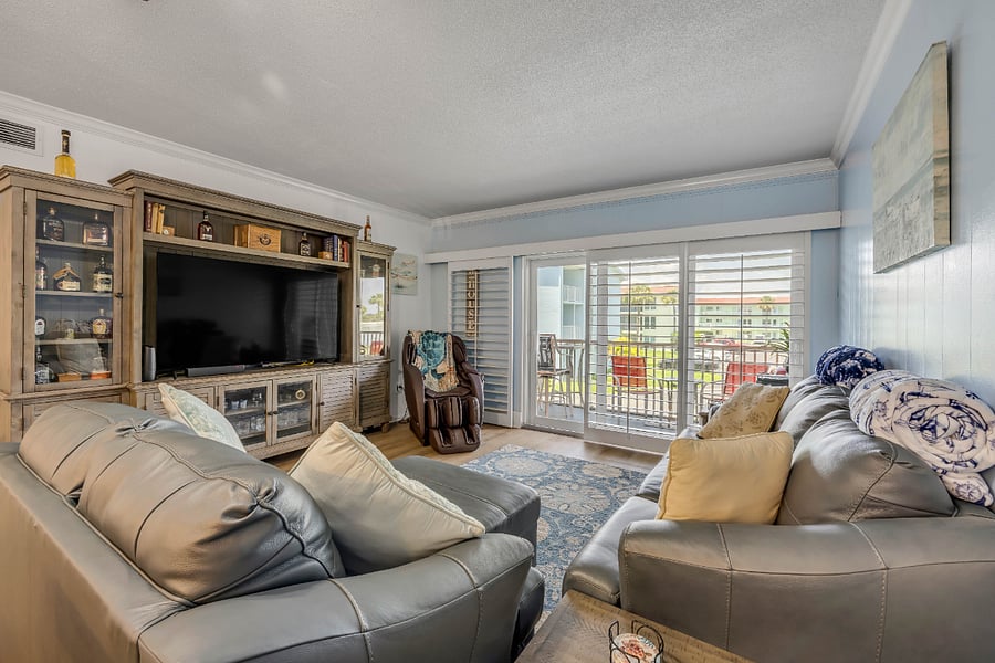 Living space with entertainment center and doors to screened in balcony