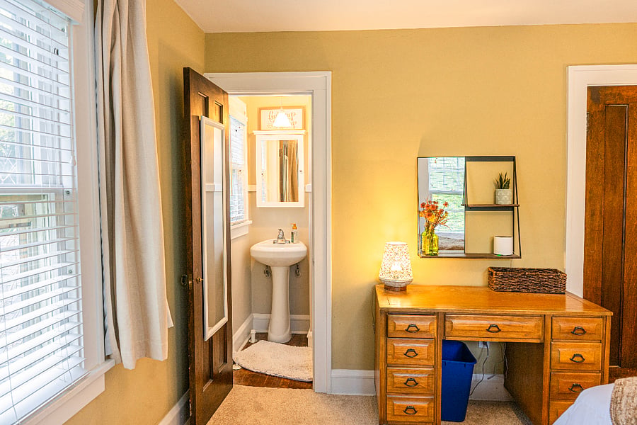Primary bedroom with private sink area and desk