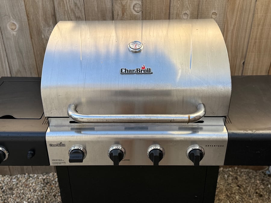 Gas grill with side burner and good lighting for barbecuing after sunset