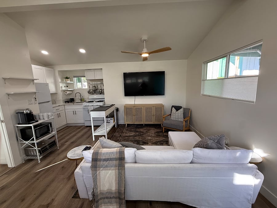 Open plan with vaulted ceilings and ceiling fan allows the space to feel much larger and eases in entertaining or relaxing. 