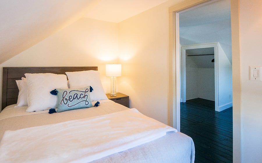Queen bedroom with large mirror and sliding drawers under the bed