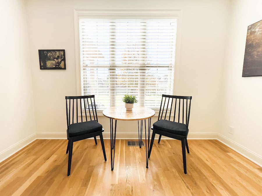 Cafe table and chairs in kitchen by window.