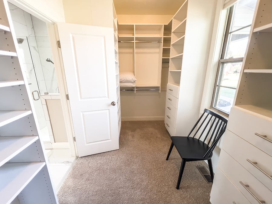 His side of the massive walk-in closet California system with so many drawers and shelves and hanging areas for clothes.