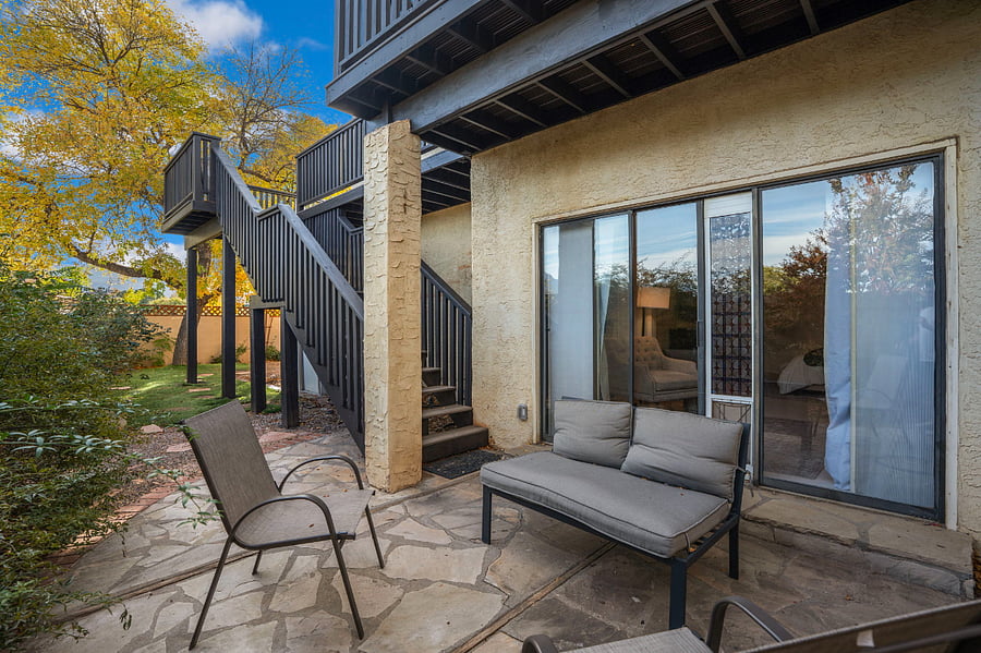 master patio with outdoor stairs to upper level and balcony
