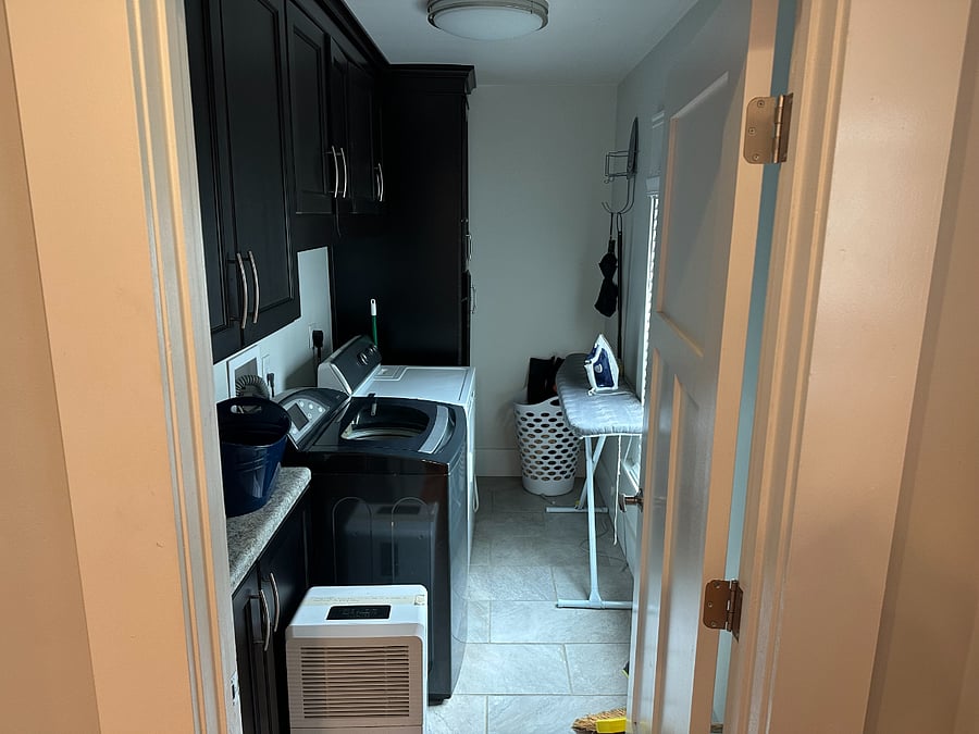 Laundry room with full-size washer and dryer. Ironing board and iron.