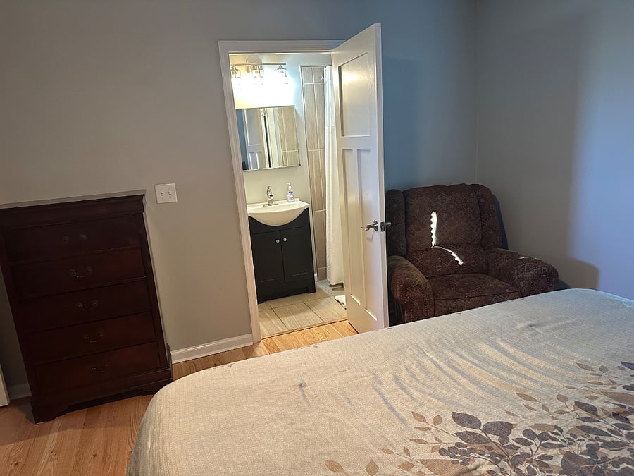 Another view with the recliner in the king bedroom upstairs with the bath with the shower