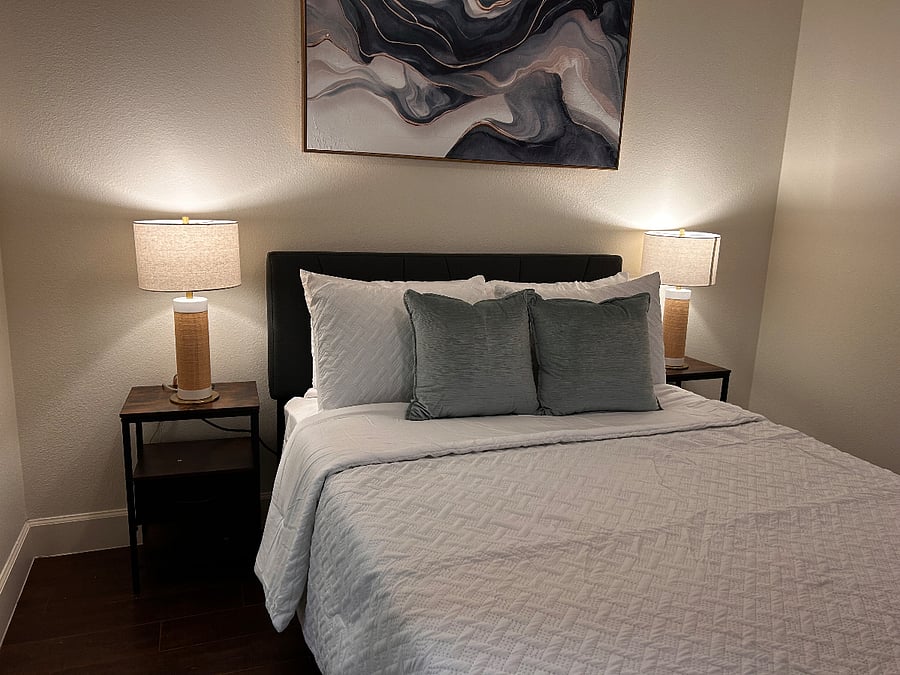 Bedroom 2 with a Full sized Bed, closet, bench and 55 inch Smart TV