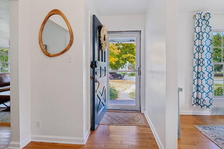 Step insideour South Bend guest retreat entry features a warm-toned mirror with organic charm and a welcoming view of the beautiful front yard. A cozy first impression near Notre Dame.