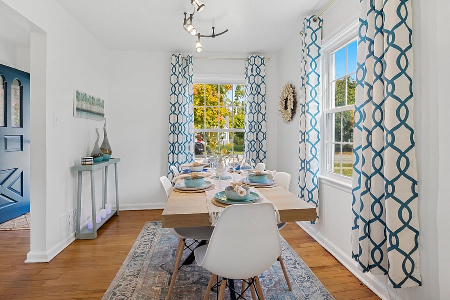 Fresh and inviting sleek chairs and warm hardwood floors frame a dining table set with beautiful dishes. Near Notre Dame, our South Bend retreat blends style and comfort.