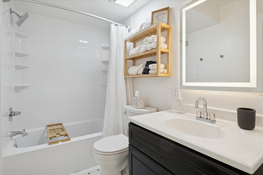 White, crisp, and spa-inspiredour South Bend guest retreat bathroom features an oversized shower head, plush linens, and a bath tray for your book and beverage. Just add steam and serenity.