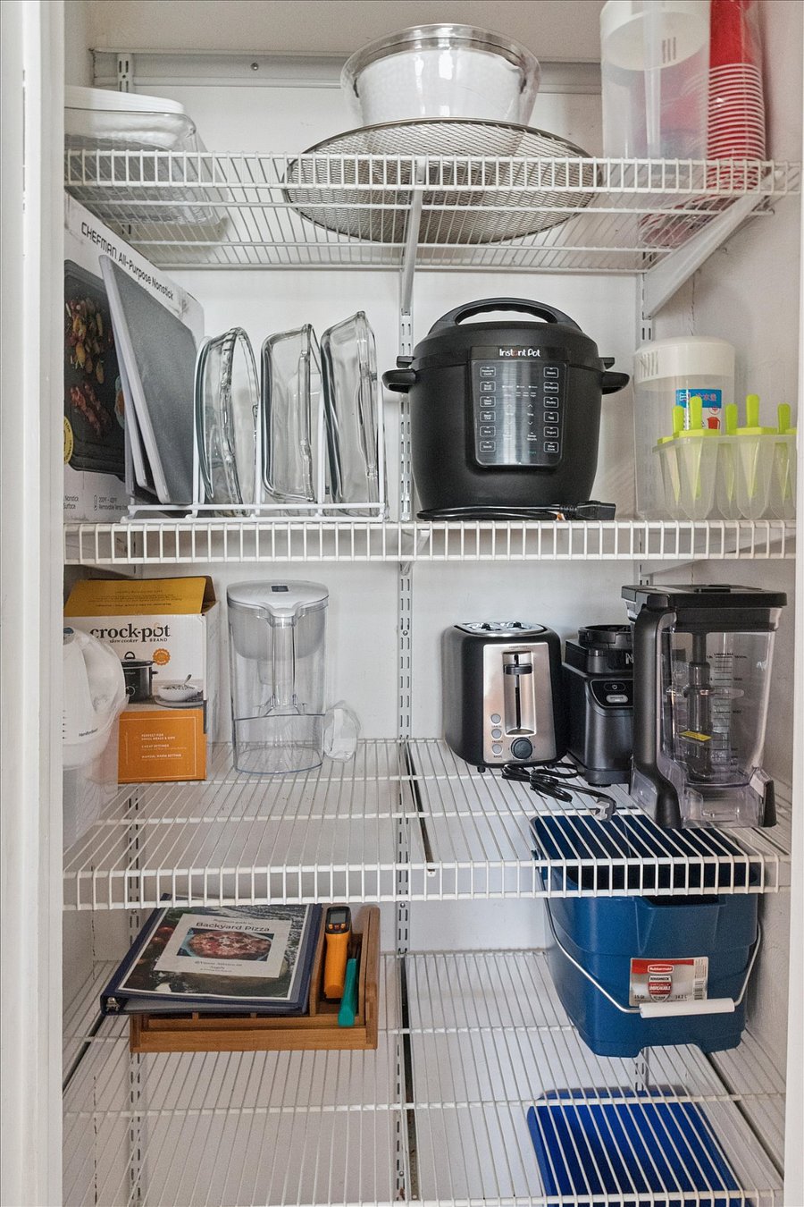 Our South Bend pantry is weekend-readystocked with toaster, blender, crockpot, baking dishes, Instant Pot, griddle, containers, serving platters, and pizza oven essentials.