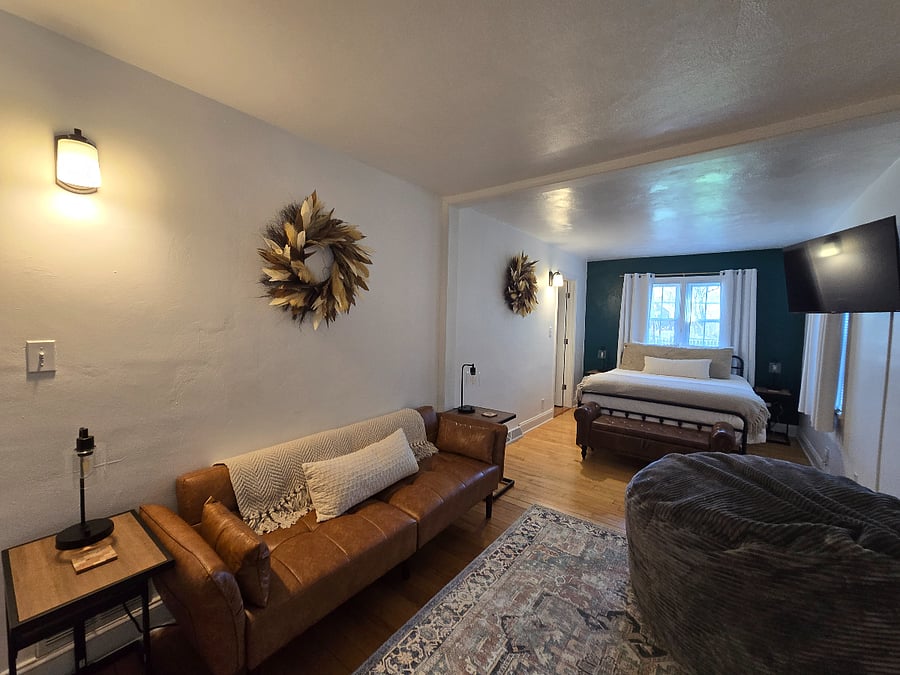 The primary suite offers a queen bed, blackout curtains, a sound machine, a swivel Roku TV, a futon, and a giant bean bag chair ideal for comfort during longer stays.