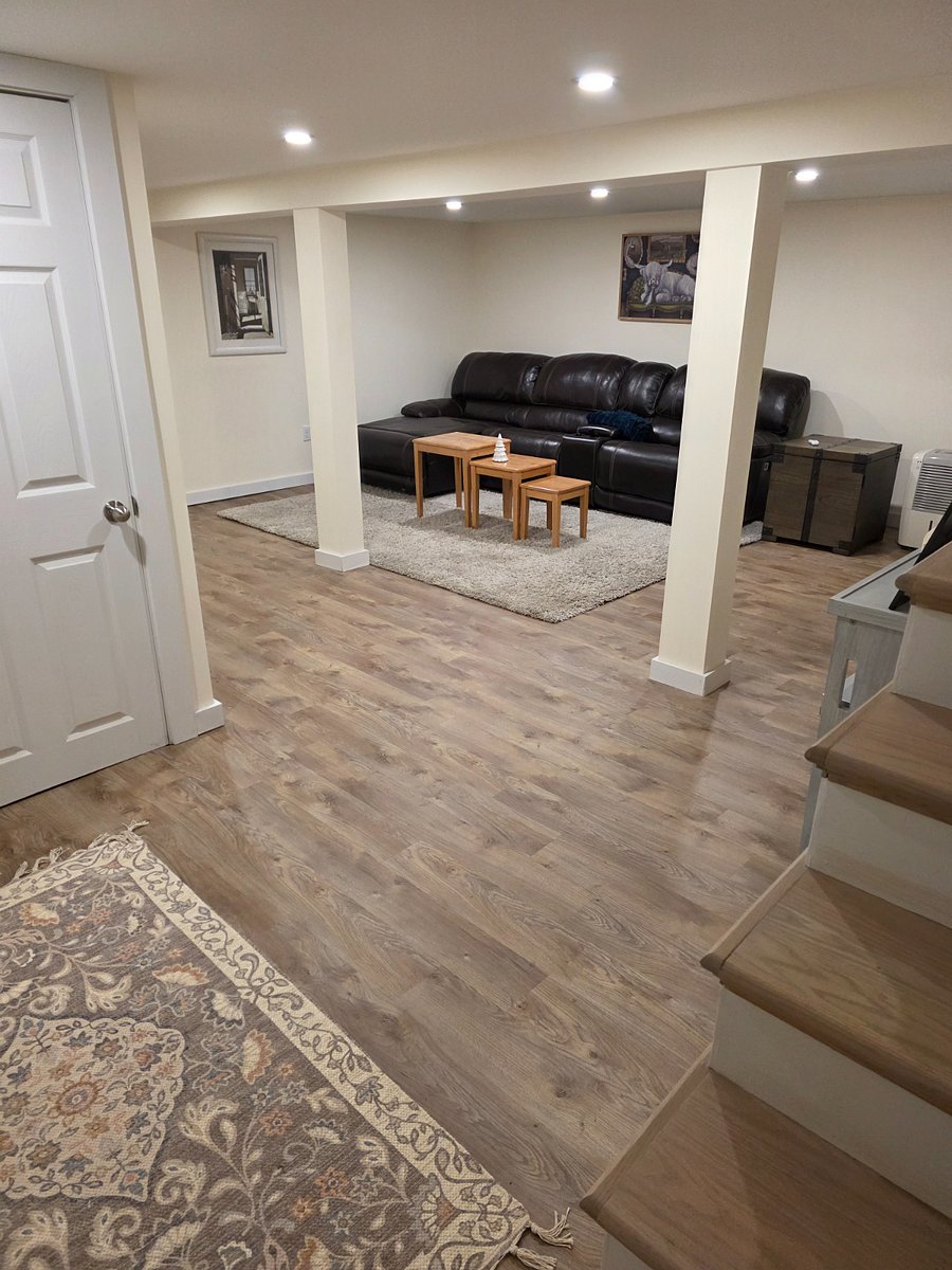 basement entertainment area with electric leather sectional and 2 TV's